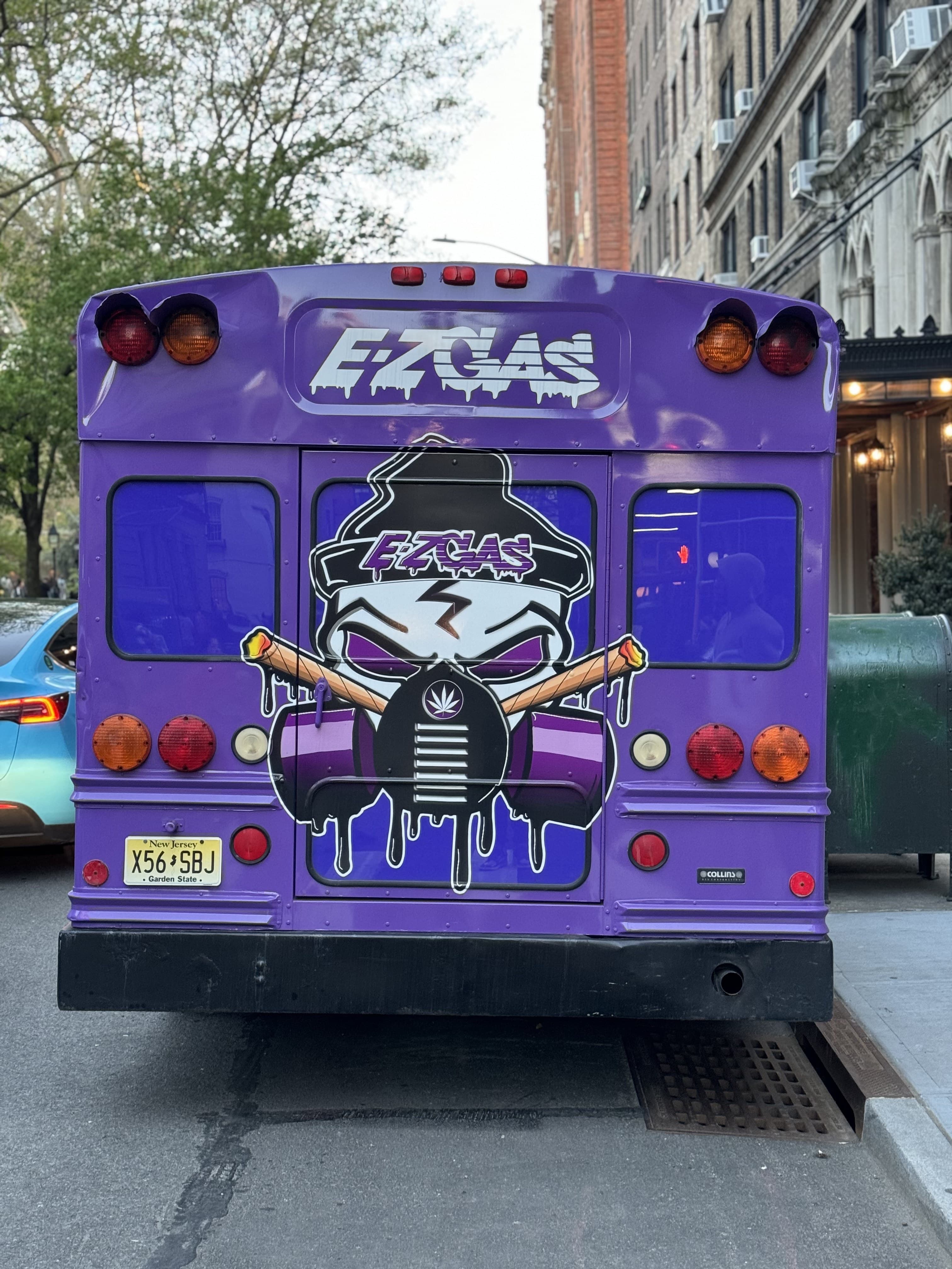 EZ Gas Co. candy-purple bus — rear-view street shot